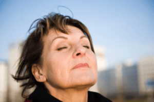 woman taking deep breath outdoors