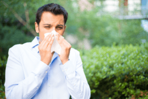 man blowing nose in tissue