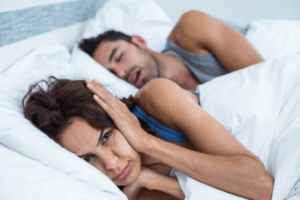 woman annoyed by husbands snoring