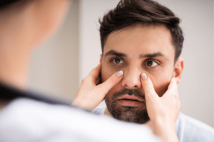 doctor examining sinuses of male patient
