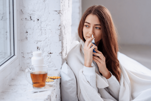 woman at home using nasal spray