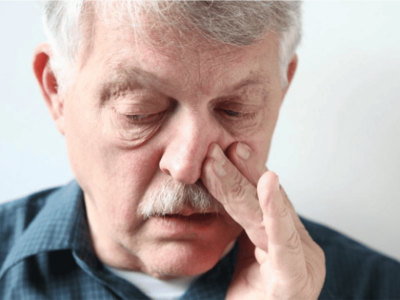 Older man pinching the bridge of his nose